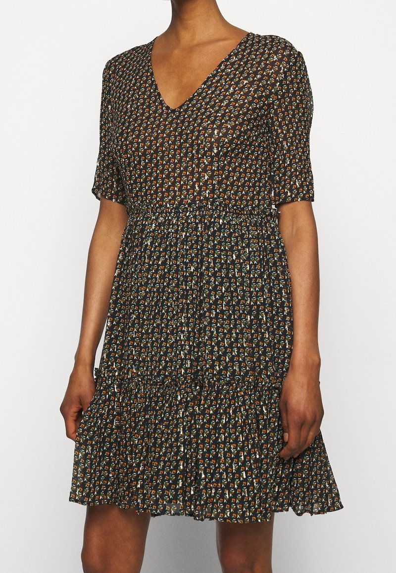 Kukkakuosiset mekko V-aukolla, lyhyillä hihoilla ja kerroksella kootulla hameella. Väriteemana musta, oranssi ja teal-kuviot.