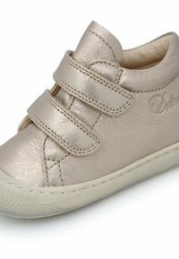 Zapatilla infantil metálica dorada con cuero texturizado, dos correas de velcro, puntera reforzada y suela de goma con un patrón de puntos.