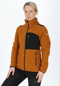 Giacca in pile arancione bruciato con accenti neri. Presenta un colletto alto, tasche con zip e un tessuto strutturato per il calore.