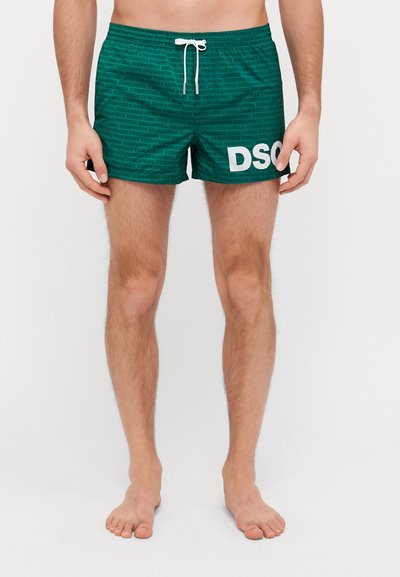 Pantaloni da mare verdi con un motivo texturizzato che presenta il testo "DSQUARED2". Finiti con un logo bianco e una vita elastica con cordino.