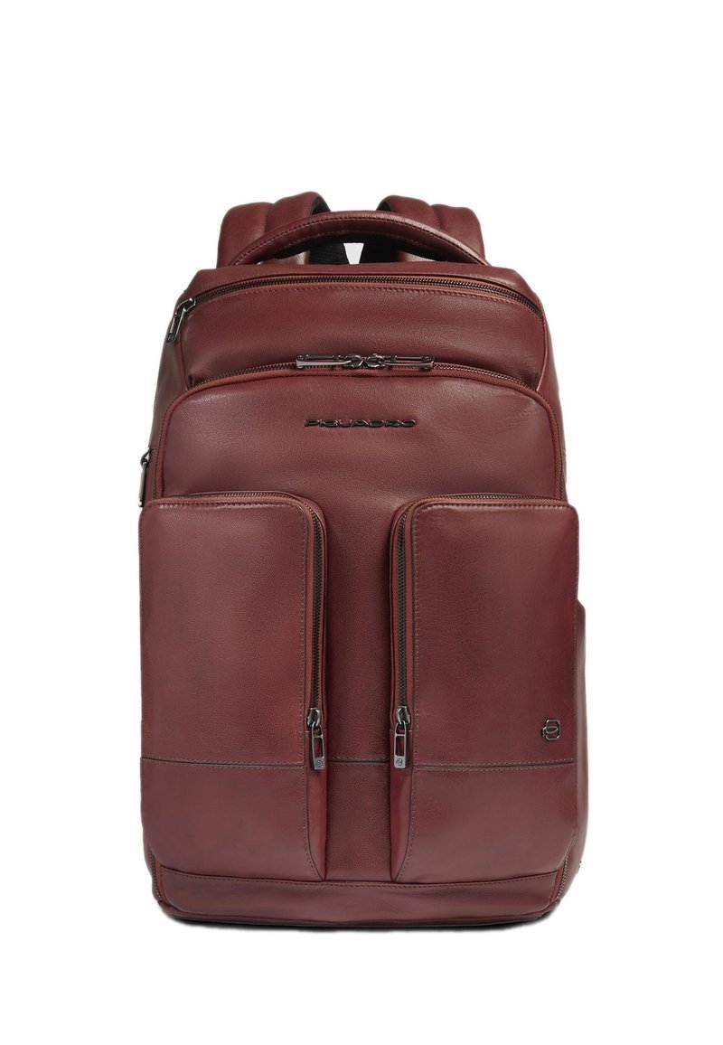 Mochila de cuero burdeos con dos bolsillos frontales con cremallera, correas acolchadas y asa superior. Textura lisa con detalles sutiles de costuras.