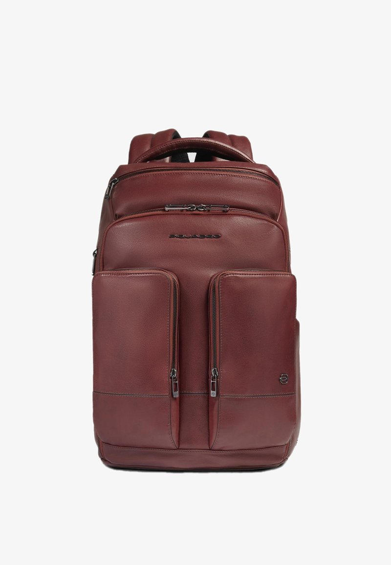 Mochila de cuero burdeos con dos bolsillos frontales con cremallera, correas acolchadas y asa superior. Textura lisa con detalles sutiles de costuras.