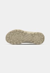 Light-colored athletic shoe sole with a textured design, featuring multidirectional lugs for grip and the "Merrell" logo prominently displayed.