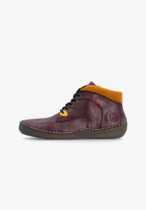 Bottine en cuir bordeaux avec col côtelé jaune, œillets multicolores, semelle noire et coutures apparentes.