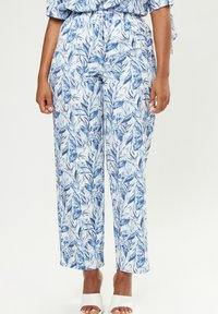 Leichte, weit geschnittene Hose in Weiß mit einem blauen Blattmuster. Der elastische Bund und die seitlichen Taschen sorgen für Komfort und Funktionalität.