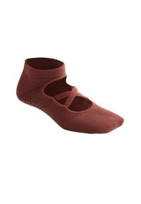 Chaussette de yoga marron jusqu'à la cheville avec des points antidérapants sous la semelle et des sangles élastiques croisées sur le dessus du pied.