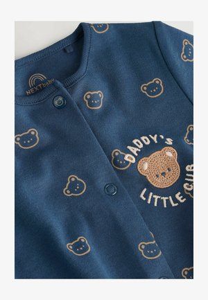 Tamsiai mėlynas medvilninis kardiganas su meškiuko raštu ir siuvinėtu tekstu "Tėčio Mažasis Kumeliukas." Yra du mėlyni mygtukai ir apvalus iškirptės dizainas.