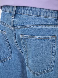 Sinine teksariie kõrge vöökoht, kaks tagakotti ja kontrastne õmblus. Kangas on peene tekstuuriga ja klassikalise disainiga.