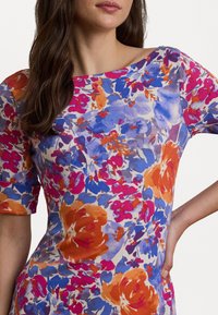 Vestito floreale con maniche corte, caratterizzato da motivi vivaci in arancione, rosa e blu su uno sfondo chiaro. Tessuto morbido e liscio.