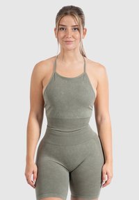 Conjunto de ropa deportiva en verde oliva que incluye un top corto sin mangas y pantalones cortos de cintura alta. Tejido suave y elástico con detalles acanalados.
