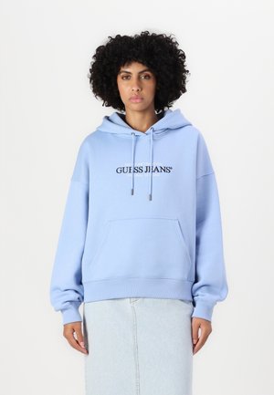 Jasnoniebieski, oversize'owy hoodie z kieszenią z przodu, regulowanymi sznurkami i logo nadrukowanym na klatce piersiowej. Wykonany z miękkiej mieszanki bawełny.