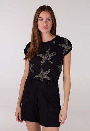 Zwarte top met korte mouwen en een zeesterpatroon in zilveren accenten, gecombineerd met hoogpanel zwarte shorts. Gladde stof met een ontspannen pasvorm.