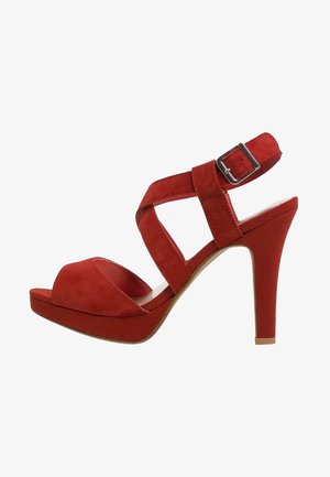 Sandal con tacco alto in suede rosso, dotata di una piattaforma, caratterizzata da cinturini incrociati e una fibbia laterale. Texture liscia e design del tacco curvato.
