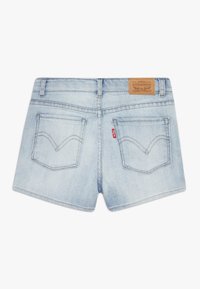 Shorts de denim azul claro, con una cinturilla alta, dos bolsillos traseros con costura arqueada y una etiqueta de logo de cuero marrón en la parte posterior.