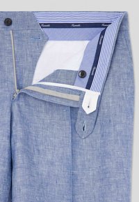 Pantaloni in lino azzurro chiaro con chiusura a zip e bottone, bavero della vita foderato a righe a contrasto e dettagli cuciti.