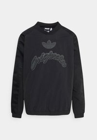 Svart pulloverjacka med elastiska ärmslut och nederkant, broderad logotyp och text på framsidan, samt en strukturerad tyg med släta ärmar.