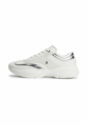 Sneaker bianco con accenti argento, suola spessa, design con lacci e piccolo logo metallico sul lato, mostrato da una vista laterale.