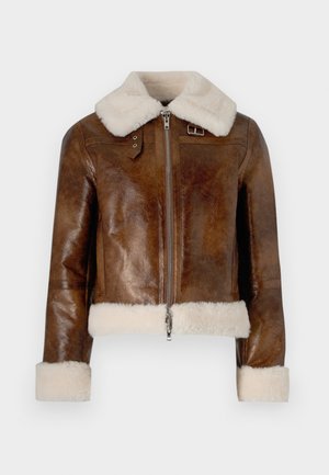 Pruun nahktagi, millel on pehme kreemivärvi krae ja mansetid, esiosas on lukuga ja kaeluses on vöödetail. Tekstuuriga viimistlus.