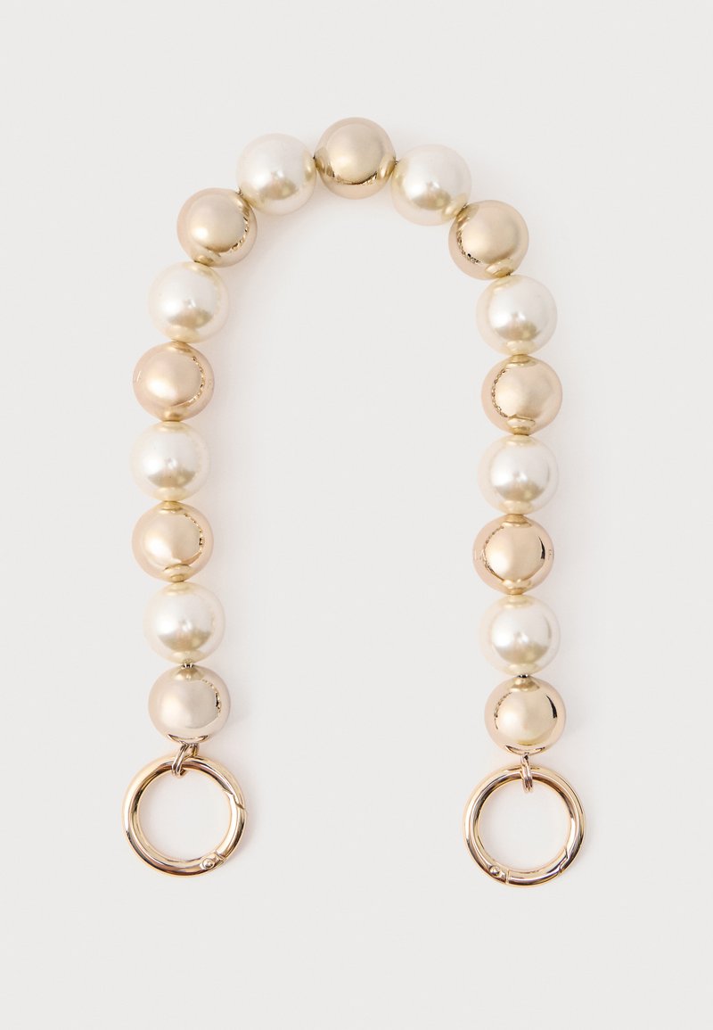 Krellītēm rotāta ķēde ar mainīgām spīdīgām baltām un bēšām pērlēm, ar zelta toņa apaļām metāla detaļām katrā galā.