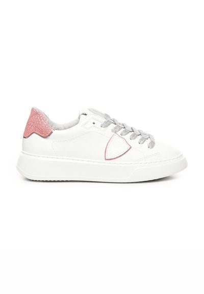Sneaker bianca in pelle con accentatura a tutto tondo in tessuto rosa sul tallone, lacci argentati, punta rotonda e suola in gomma. Design pulito con dettagli minimi.