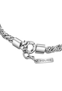 Bracciale intrecciato in argento con chiusura metallica e targhetta incisa con la scritta "POLICE". Presenta una superficie liscia e elementi di design modulare.