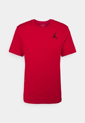 Czerwona bawełniana koszulka z krótkim rękawem, z czarnym logo Jordana na górze po lewej stronie. Okrągły dekolt, gładka tekstura, klasyczny krój.