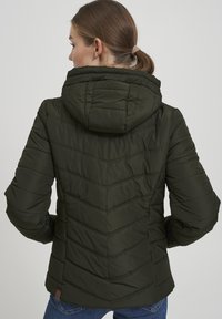 Olive green puffer jacket with a hood, featuring a quilted chevron pattern, elasticized cuffs, and a fitted design.