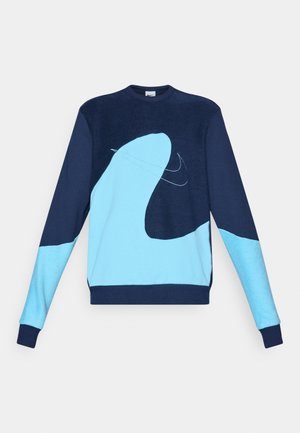 Tumedat sinine dressipluus helesinise abstraktse mustriga; omab ümarat kaela ja soonikuid varrukates. Materjal paistab olevat pehme ja tekstuurne.