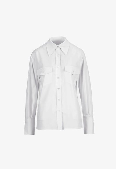 Chemise blanche à manches longues avec col pointu et deux poches à rabat sur la poitrine, présentée sur un fond blanc uni.