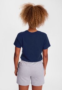 Navy blue cotton t-shirt with short sleeves, paired with gray cotton shorts. Features a simple design with a round neckline and relaxed fit.