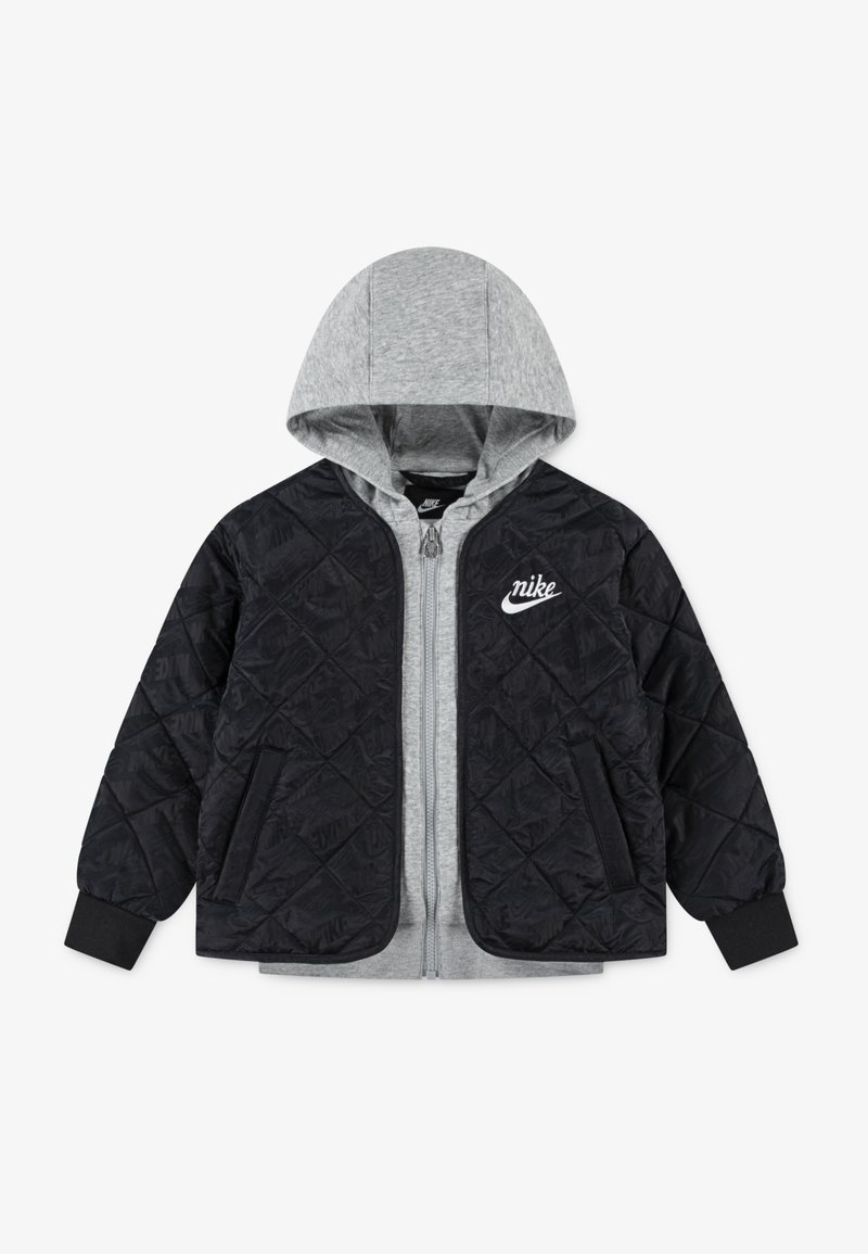 Veste bomber rembourrée avec un extérieur noir matelassé, une doublure à capuche grise et une fermeture éclair à l'avant. Elle dispose de poches latérales et d'un logo blanc sur la poitrine.