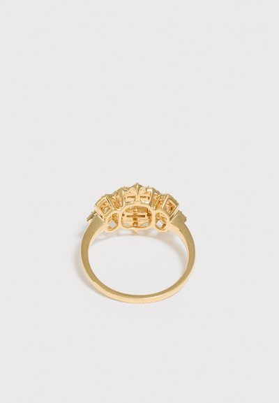 Bague en or avec un sertissage détaillé et orné comprenant plusieurs petites pierres précieuses, présentée sur un fond blanc uni.