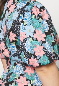 Blumenmuster-Kleid mit schwarzem Grund, das mehrfarbige Blumen in Blau, Pink und Grün zeigt. Puffärmel und geraffte Details betonen das Design.