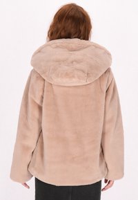 Beige faux fur jakke med en stor hætte, der har en blød tekstur, faldende skuldre og en afslappet pasform. Glat, rund kant.
