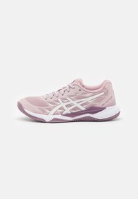 Zapatilla deportiva de color rosa claro con parte superior de malla, acentos blancos y cuello acolchado. Presenta una suela externa texturizada de color púrpura y diseño de cordones.