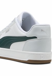 Zapatilla blanca de cuero con una franja de ante verde, que presenta una parte trasera texturizada, suela de goma y el logo de Puma en plata en el lateral y en el talón.