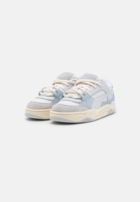 Tenisky s kombinací světle modré a šedé semišové kůže a hladké kůže, s krémovými tkaničkami, polstrovaným límcem a texturovanou podrážkou.