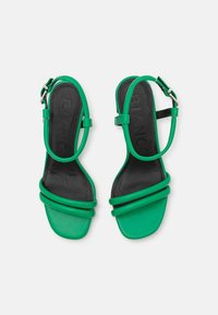 Sandales synthétiques vertes à bout ouvert avec double lanière avant et lanière de cheville. Semelle intérieure noire avec "BIANCO" embossé. Semelle plate.