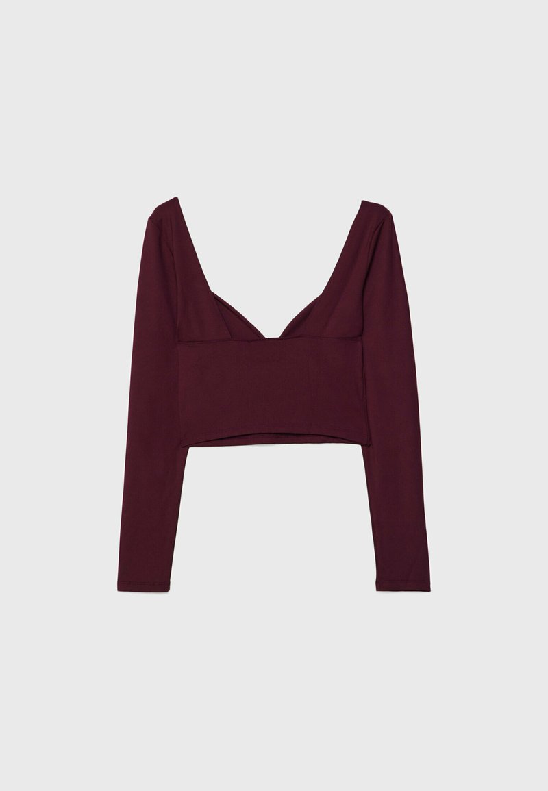 Crop top borgogna a maniche lunghe con scollatura a V profonda e design strutturato, caratterizzato da un corpo aderente e un tessuto leggermente texturizzato.