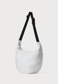 Weiche, gepolsterte Schultertasche aus hellgrauem Stoff. Verfügt über einen verstellbaren schwarzen Riemen und hat eine unregelmäßige, rundliche Form mit einer glatten Textur.