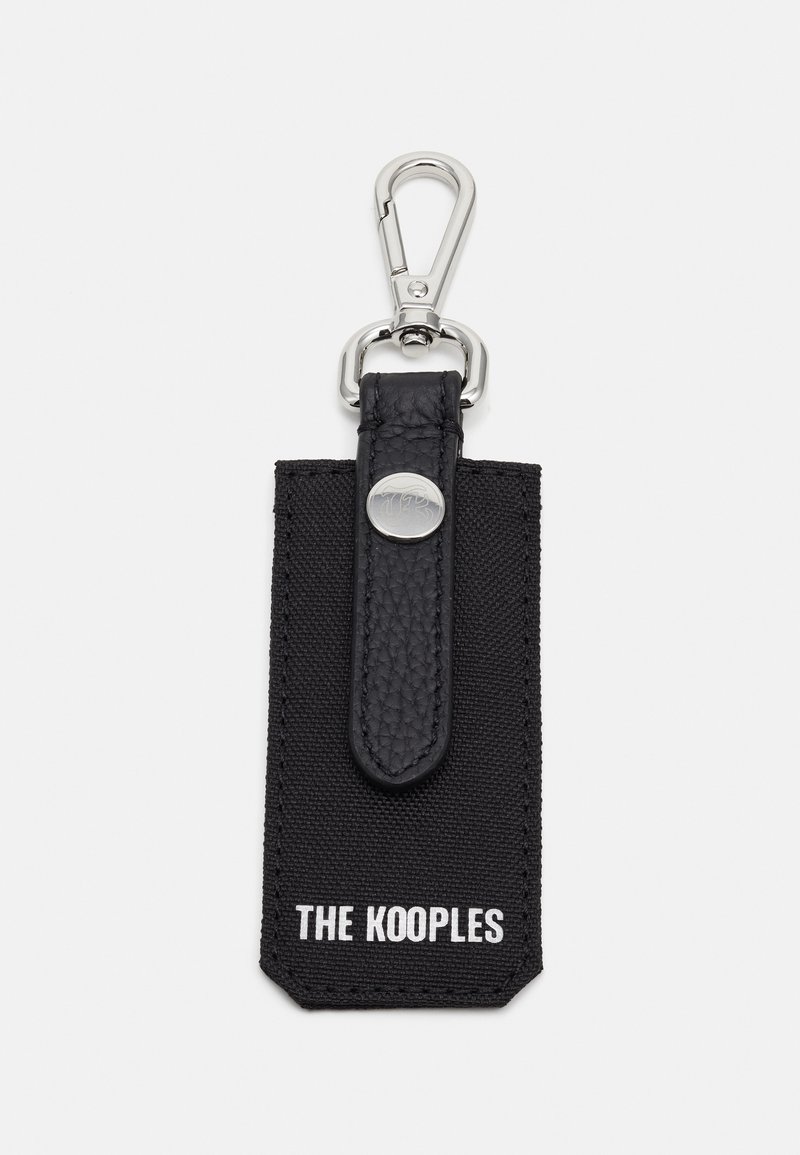 Μαύρο μπρελόκ με υφασμάτινη ταινία από δέρμα με υφή, μεταλλικό κλιπ και ορθογώνιο ετικέτα από ύφασμα με τη σήμανση "THE KOOPLES" τυπωμένη σε λευκό χρώμα.