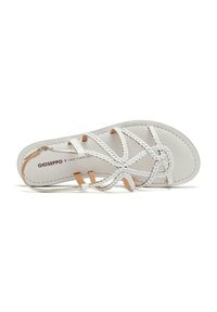 Sandalias trenzadas blancas con suela plana, que cuentan con detalles de cuero y un diseño minimalista. La plantilla tiene un logo impreso.