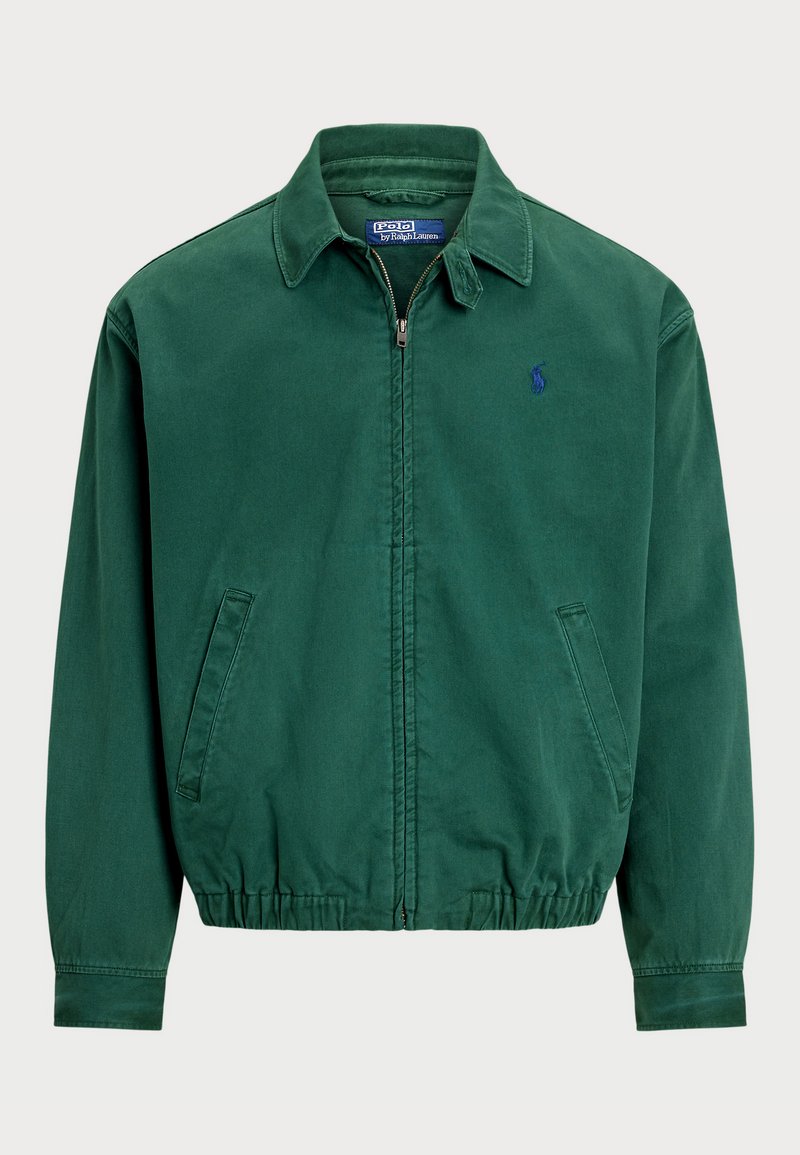 Grøn lynlåsjakke med krave, som har sidelommer og elastisk talje. Indeholder et lille blåt logo på brystet.