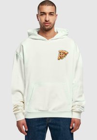 Felpa bianca in cotone, con una grafica a forma di fetta di pizza sul petto sinistro. Ha una tasca a marsupio e una vestibilità comoda.