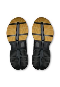 Semelles de chaussures noires et brunes présentant un design texturé avec une section en caoutchouc gomme jaune, marquées "Cloudtec" et "Speedboard."