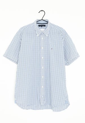 Kurzärmliges Hemd mit Knopfleiste und weiß-blau kariertem Muster, das an einem schwarzen Bügel vor weißem Hintergrund hängt.