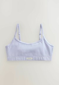Bralette lilla chiaro con spalline regolabili, tessuto di cotone liscio e un piccolo etichetta con tre simboli a forma di cuore sul davanti.