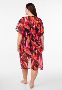 Kimono transparente en negro con un vibrante patrón floral que presenta tonos de rosa y naranja. Corte holgado con mangas hasta el codo y cinturón a la cintura.