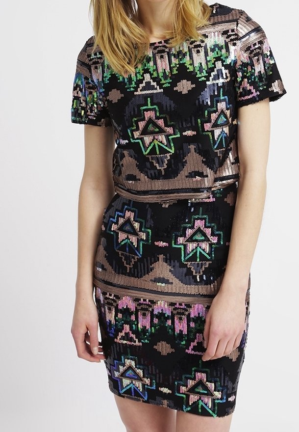 Černé šaty s krátkými flitrovými rukávy a složitým geometrickým vzorem v zelené, modré, růžové a bronzové barvě. Upnutý střih zvýrazňuje siluetu.