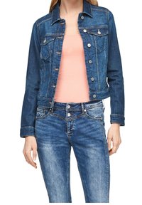 Chaqueta de mezclilla con mangas largas, dos bolsillos en el pecho y cierres de botón. Presenta un color azul medio con un ligero desgaste y detalles desgastados.